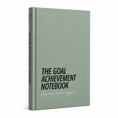 The Goal Achievement Notebook shown at an angle, with a sage green hardback cover and Ideas. Plans. Actions. Progress. design.