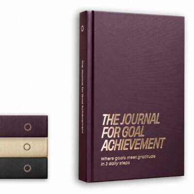 The Journal for Goal Achievement from Goal Achievement Hub in Plum, featuring a sleek black hardcover with embossed silver lettering.